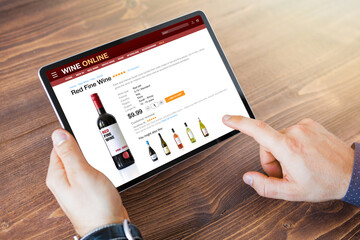 Person holding tablet and buying wine online