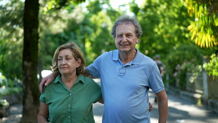 Happy senior couple in 60s walking embracing each other, old age relationship