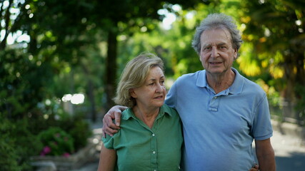 Happy senior couple in 60s walking embracing each other, old age relationship