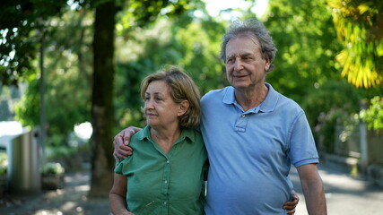 Happy senior couple in 60s walking embracing each other, old age relationship