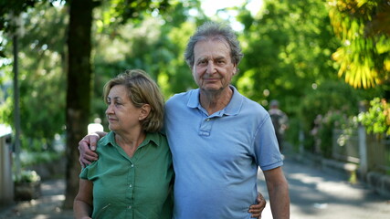 Happy senior couple in 60s walking embracing each other, old age relationship