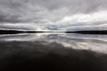 Dramatic autumn clouds reflection in Muonio lake, Lapland, Northern Finland