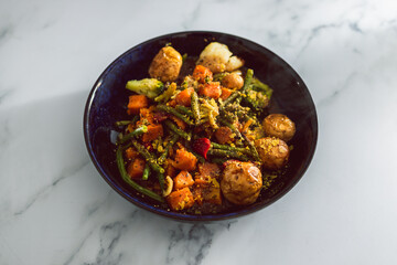 vegan mixed vegetable roast with gravy sauce, healthy plant-based food