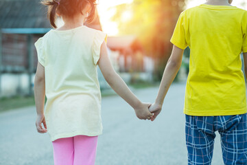parent holds the hand of a small child