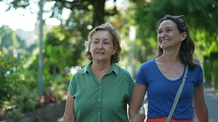 Happy mother and adult daughter smiling and laughing outside