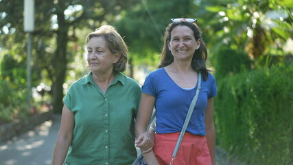 Happy mother and adult daughter smiling and laughing outside