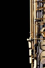 A black saxophone with gold plated keys on a black background
