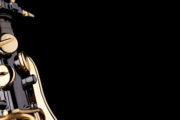 Obraz premium A black saxophone with gold plated keys on a black background