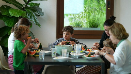 Family sitting at table eating food indoors