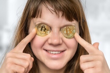 Woman with bitcoin coins in front her eyes