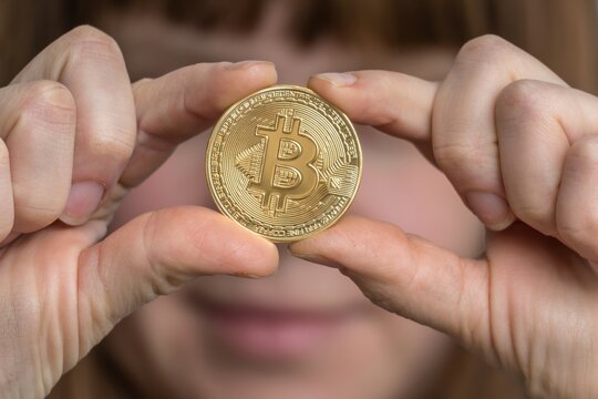 Woman with bitcoin in her hand - cryptocurrency concept