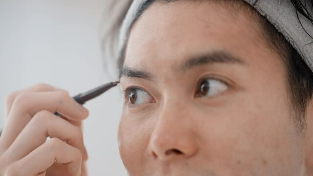 眉メイクをする若い男性　ビューティーイメージ