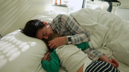 Obraz premium Child and mother affection cuddle in bed together
