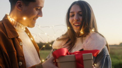 Giovane coppia ragazzo e ragazza con luci led festeggia il san Valentino in un parco naturale