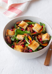 Salad with pumpkin, pomegranate, pecans and croutons. Healthy eating. Vegetarian food.