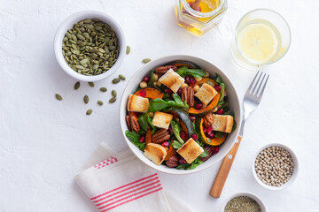 Salad with pumpkin, pomegranate, pecans and croutons. Healthy eating. Vegetarian food.