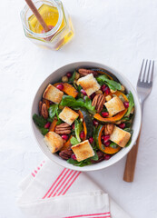 Salad with pumpkin, pomegranate, pecans and croutons. Healthy eating. Vegetarian food.