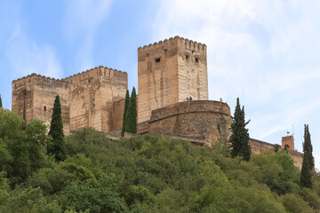 Fototapeta na wymiar View at the Alhambra citadel towers fortress, from Paseo de los Tristes, walk of the sad (The Promenade of the Sad), Granada, Spain