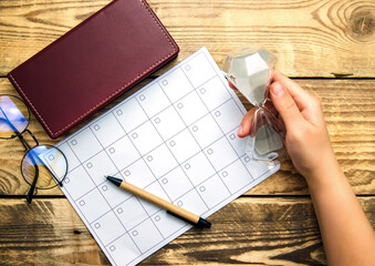 A blank sheet of notepad and a calendar for planning for a month or a year. Glasses, notepad and...