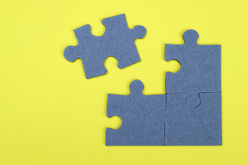 Unfinished puzzle on a yellow background, business concept, goal achievement