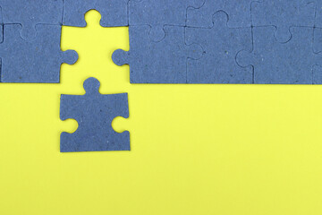 Unfinished puzzle on a yellow background, business concept, goal achievement