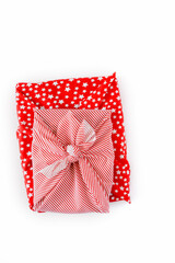 two gifts wrapped in red holiday furoshiki wrapping cloth with stars, candy cane tripes and shepherd s check. Eco-responsible eco-friendly sustainable decorative cloth