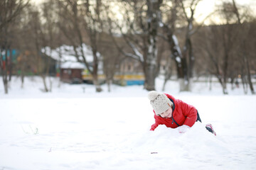 Children play outside in the winter. Snow games on street.
