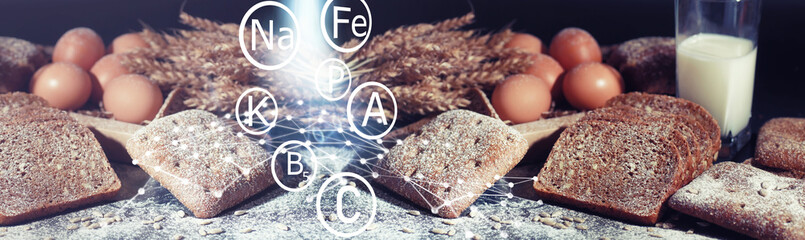 Fresh loaves of bread with wheat and gluten on a black table. Bakery and grocery concept. Fresh,...