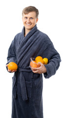 portrait of a man in a gray terry bathrobe. Satisfied, happy man holds fruits, oranges. better at home, stay home. vitamins protect you from disease. isolated.