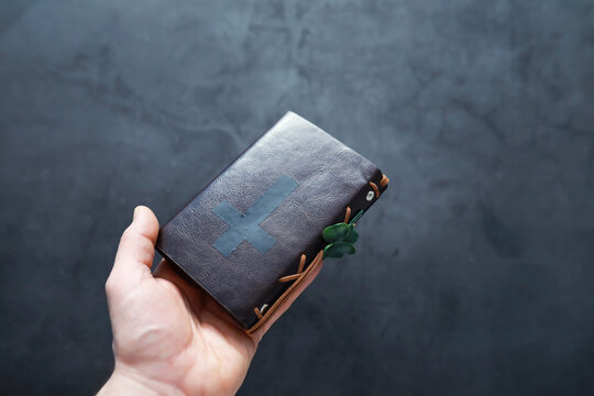 A leather-bound Bible on the table. Religious Christian Irish celebration. Four-leaf clover symbol of good luck.