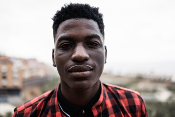 Young african guy looking serious at camera outdoor - Focus on face