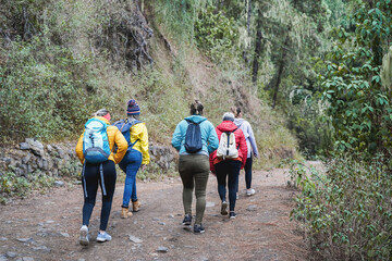 Multiracial women having fun during trekking day in mountain forest - Focus on african woman head