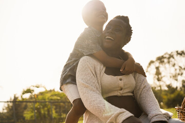 Happy pregnant mother and son having tender moment at city park