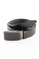 Fastened fashionable men's leather belt with dark matted metal buckle isolated on white background.