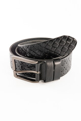 Fastened fashionable men's leather belt with dark matted metal buckle isolated on white background.