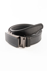 Fastened fashionable men's leather belt with dark matted metal buckle isolated on white background.