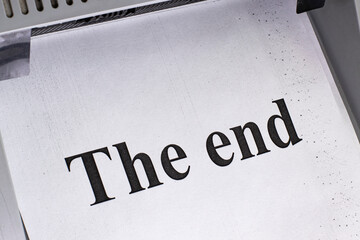 A sheet of paper on an office printer with the inscription The end, close-up.