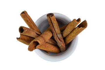 Cinnamon sticks in a white ceramic cup, top view, close-up