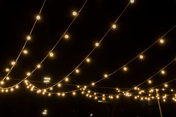 Bright garlands against the background of the night sky, point of view street photo