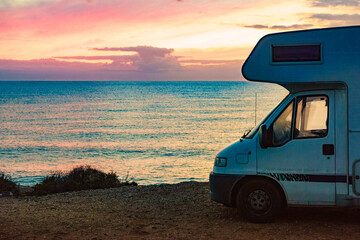 Camper vehicle on beach at sunrise