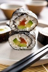 Sushi rolls close up with salmon, avocado and cucumber.
