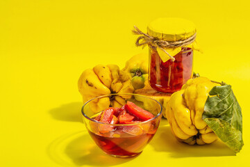Ripe whole quince and sweet jam from it isolated on yellow background