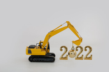 Concept Happy new year 2022,excavator of lift up bucket that is installing the ball .