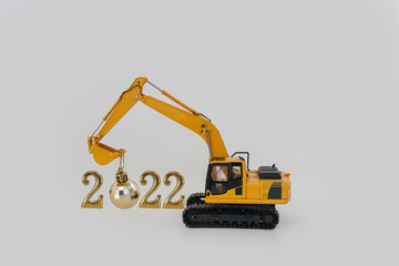 Concept Happy new year 2022,excavator of lift up bucket that is installing the ball .