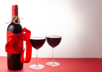 bottle of red wine with red ribbon and glasses of wine. February 14 Valentine's Day
