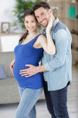 Fototapeta premium handsome man and his beautiful pregnant wife are hugging