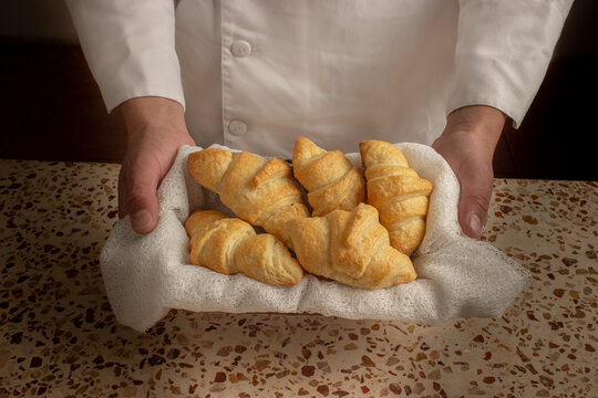 panadero mostrando cesta de croissant