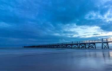 Pier extending into the sea at Saint-Jean-de-Monts in France, after sunset. Overcast.