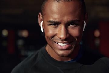 Athletic black man listening music in earphones