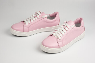 Light pink faux leather shoes laced with laces. Close-up shot.